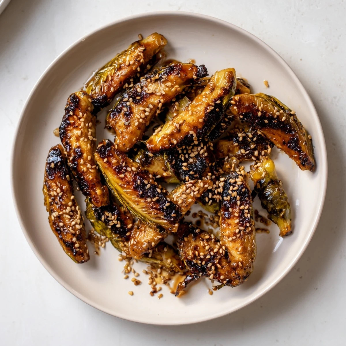 Golden-brown, crispy Honey-Soy Glazed Brussels Sprouts served with sesame seeds, a delicious Asian-inspired side.