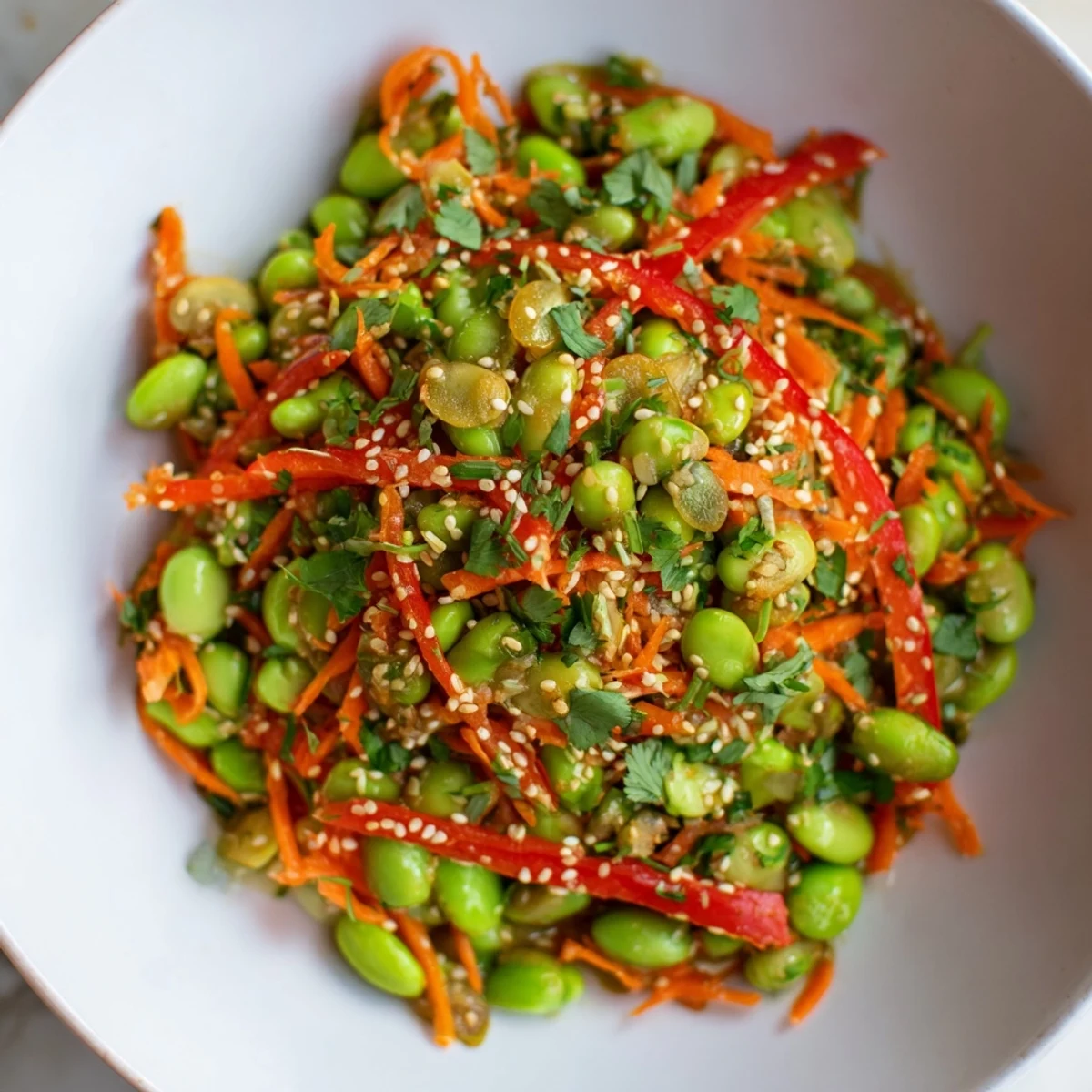 Close-up of a refreshing Asian Edamame Salad, featuring colorful ingredients and crunchy toppings in a bowl.