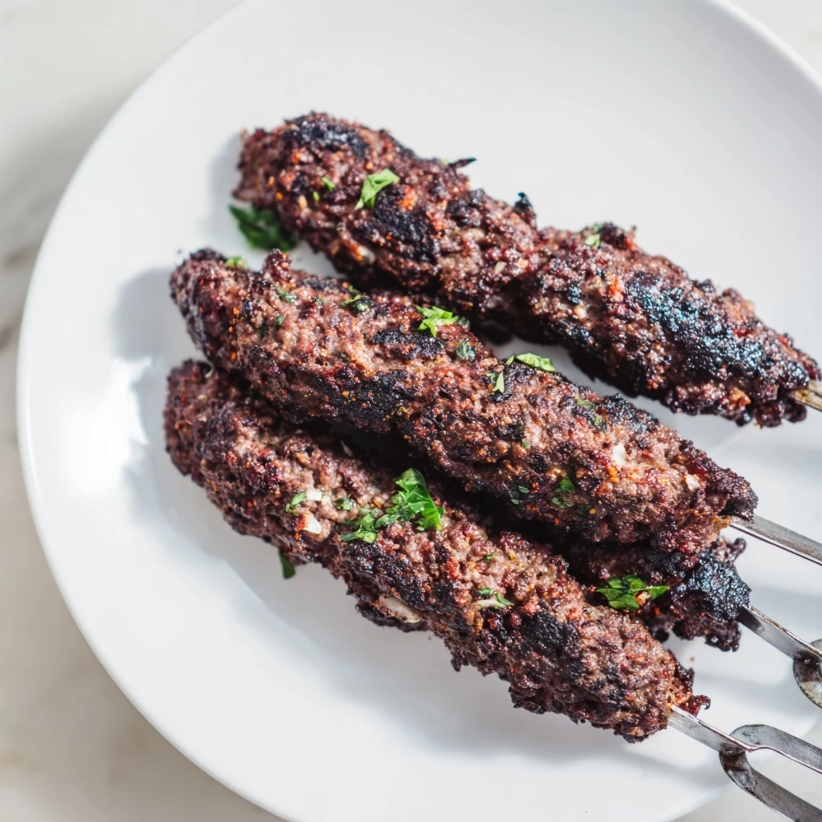 Smoky Iraqi Kebab Tikka skewers, grilled to perfection, offer savory, spiced ground meat flavors on the grill.
