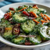 The crunchy, chilled cucumber salad glistens with sesame seeds beside a serving fork.  