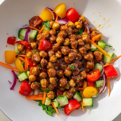 A refreshing close-up of BBQ Chickpea Salad, showcasing vibrant tomatoes and crisp cucumber pieces.