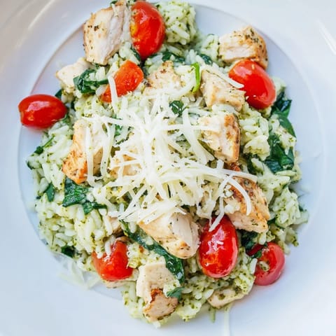 A golden, bubbly Chicken Pesto Rice Bake topped with Parmesan, ready for a comforting family dinner.