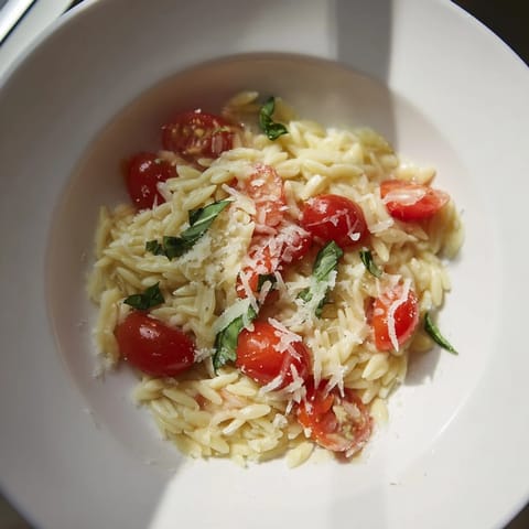 Golden orzo pasta with juicy tomatoes and Parmesan cheese, a taste of Mediterranean in this recipe.