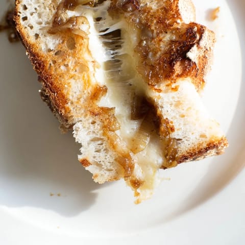 This Caramelized Onion & Gruyère Grilled Cheese features deeply golden onions and melted Gruyère nestled between crispy slices of rustic country bread.