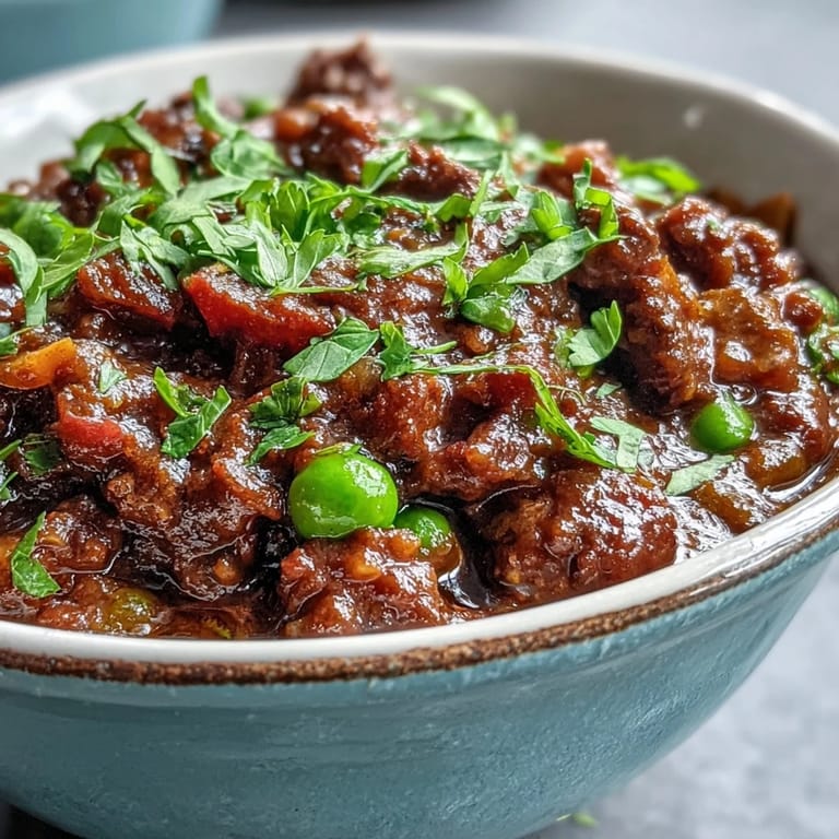 Close-up of Venison Keema Curry revealing golden ground venison, vibrant green peas, and a warm, rustic gravy.