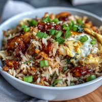 Fluffy Chili Crisp Egg Fried Rice topped with fresh scallions and crunchy chili oil.